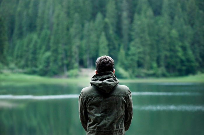 A man standing in front of a lake