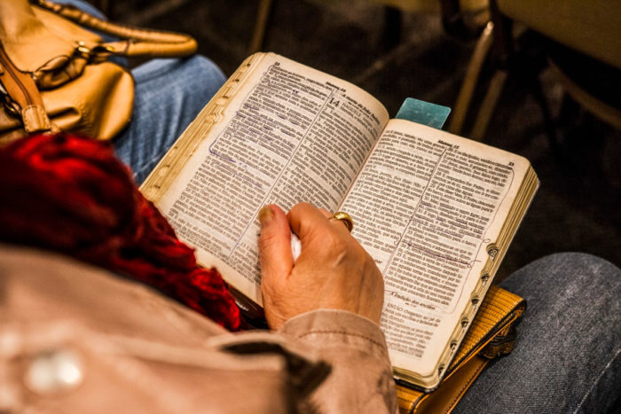 A woman holding a bible on her knees